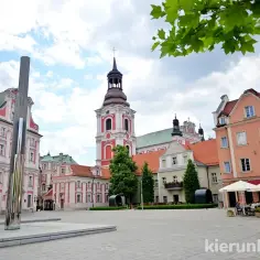 Plac kolegiacki w Poznaniu z barokową architekturą i nowoczesną rzeźbą.