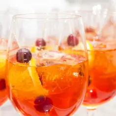 Orzeźwiające drinki z pomarańczą i wiśniami, idealne na lato. Dowiedz się, jak zrobić klarowny lód do drinków w domowej zamrażarce, by Twoje napoje wyglądały profesjonalnie.