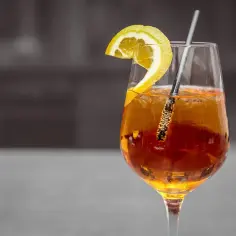 Orzeźwiający drink z Metaxą, plasterkiem cytryny i słomką. Idealny na letnie wieczory. Metaxa z czym pić? Z cytryną i lodem!