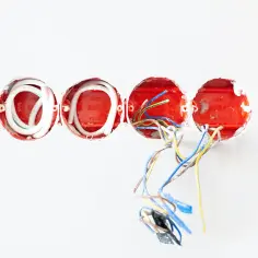 Instalacja elektryczna w trakcie prac. Widoczne puszki podtynkowe z przewodami, gotowe do tego, jak rozgałęzić kabel elektryczny.