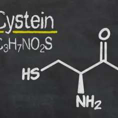 Struktura chemiczna cysteiny: C₃H₇NO₂S. Ta aminokwasowa cząsteczka zawiera grupę tiolową (HS), która jest kluczowa dla jej funkcji.