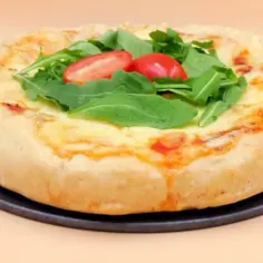Puszyste brzegi pizzy, idealne do zrobienia, z rukolą i pomidorkami.