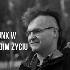 Mężczyzna z irokezem i okularami, uśmiechnięty. Napis "PUNK W MOIM ŻYCIU" sugeruje, że punk rock to jego pasja.