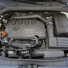 Silnik 2.0 TSI Audi z widocznym osprzętem, układem dolotowym i zbiorniczkiem płynu chłodniczego.
