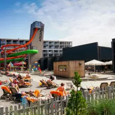Słoneczny dzień w Mielnie Aquapark. Kolorowe zjeżdżalnie wodne, leżaki z opalającymi się ludźmi i baseny tworzą wakacyjną atmosferę.