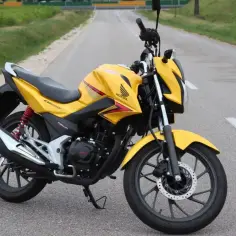 Żółty motocykl Honda CBF 125F, gotowy do jazdy, z napisem "v-max" na baku.