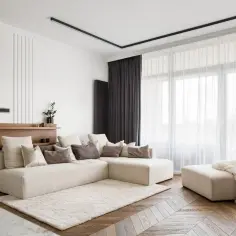 Nowoczesny salon z beżową sofą, dywanem i ukrytym karniszem LED nad oknem.