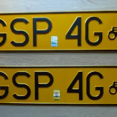 Dwie żółte tablice rejestracyjne z napisem GSP 4G i wizerunkiem starego samochodu.