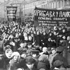 Tłum ludzi na ulicy, niosący transparenty. Jeden z nich głosi: "Dodatek do racji żywnościowych dla rodzin żołnierzy, obrońców wolności i ludu". To wyraz opozycji wobec ówczesnej sytuacji.
