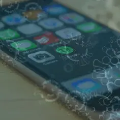 Największe mity o czyszczeniu telefonów komórkowych alkoholem izopropylowym. Wirusy otaczają ekran smartfona z ikonami aplikacji.
