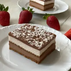 Szybkie ciasto z serkiem mascarpone, czekoladą i wiórkami kokosowymi, ozdobione świeżymi truskawkami.