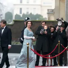 Królowa w błękitnej sukni i z tiarą wychodzi z limuzyny, otoczona przez paparazzi. Scena jak z opery mydlanej.