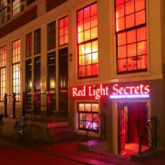 Neonowy szyld "Red Light Secrets Museum of Prostitution" nad wejściem do muzeum seksu w Amsterdamie.