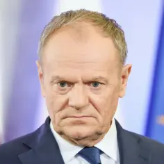 Donald Tusk zamyślony, w tle flagi Polski i UE. Czy najnowszy sondaż wyborczy CBOS przyniesie mu sukces?