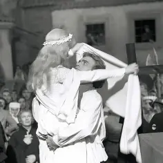 Zbyszko z Bogdańca w objęciach pięknej Danusi, z krzyżem w dłoni, na tle tłumu.