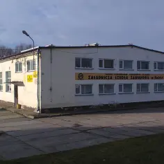 Budynek z napisem "Zasadnicza Szkoła Zawodowa w Kolnie". To miejsce, gdzie zdobywa się konkretne umiejętności zawodowe, co to znaczy wykształcenie zasadnicze zawodowe.