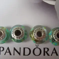 Cztery szklane charmsy Pandora w odcieniach zieleni i błękitu. Czy bransoletki z Pandory się rozciągają? Te charmsy są dowodem na to, że można je dowolnie komponować.