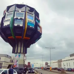 Dziwna budowla w Berlinie, a obok ruchliwa ulica. Czy Berlin jest bezpieczny? Ludzie spacerują, jeżdżą samochody.