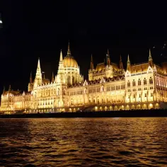 Wspaniały budynek Parlamentu w Budapeszcie nocą, widziany z Dunaju. Idealny widok podczas rejsu po Dunaju w Budapeszcie.