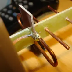 Elementy DIY anteny do telewizora z puszki: miedziane przewody, płytka drukowana i lut.
