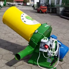 Zielona maszyna z żółtym lejkiem, służąca do rozdrabniania słomy na pellet.