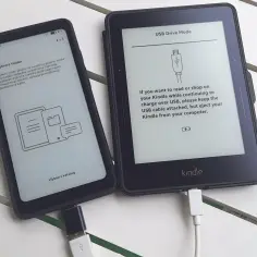 Telefon z aplikacją Legimi i Kindle podłączone kablem USB. Na ekranie Kindle widnieje komunikat "USB Drive Mode", a na telefonie "Wybierz folder".