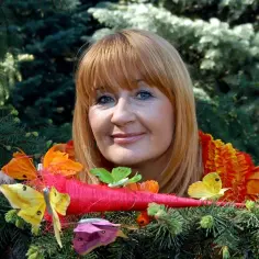 Majka Jeżowska, uśmiechnięta wśród kolorowych motyli, jakby zapraszała do wspólnego śpiewania piosenki dla dzieci.