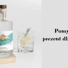 Butelka z etykietą ryby, szklanka z cytryną i napisem "Pomysł na prezent dla wędkarza".