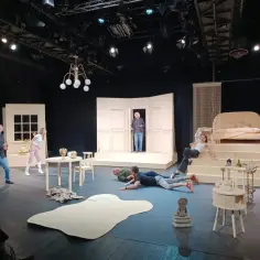 Scena teatralna pełna postaci w komicznych pozach. Czy to początek wielkiej farsy?