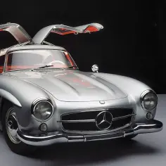Srebrny Mercedes 300 z otwieranymi do góry drzwiami, prezentujący swoje kultowe skrzydła.