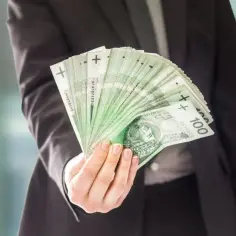 Dłoń w garniturze trzyma wachlarz banknotów 100 zł. To może być podsumowanie dzisiejszych stalexport notowań.