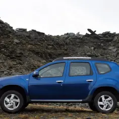 Niebieski SUV do 30 tys. gotowy na terenowe wyzwania, zaparkowany na tle skalistego zbocza.
