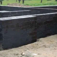 Fundamenty pokryte czarną masą izolacyjną, która chroni je przed wilgocią. To ważny etap budowy, bo jaki dysperbit do fundamentów, taki trwały dom.