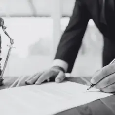 Prawnik podpisuje dokument, obok stoi Temida. To ważna decyzja administracyjna.