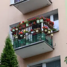 Kwiaty na balkonie w bloku. Czy można dobudować balkon w bloku? Ten przykład pokazuje, jak można go udekorować.