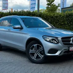Srebrny Mercedes-Benz GLC na brukowanym podjeździe. Sprawdź atrakcyjną mercedes glc cena.