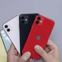 Ręce trzymające kilka iPhone'ów w różnych kolorach: czerwonym, czarnym, białym, zielonym i żółtym. Dowiedz się, jak przenieść dane z Androida na iPhone po konfiguracji.