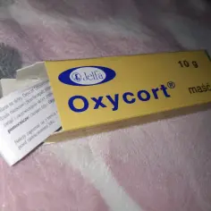 Żółte opakowanie maści Oxycort z niebieskim logo Jelfa. Maść Oxycort pomaga na stany zapalne skóry.