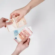 Dwie ręce przekazują sobie banknoty euro. To obecna waluta holandii, używana do codziennych transakcji.