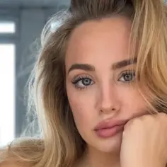 Wiktoria Gąsiewska, młoda kobieta o blond włosach i zielonych oczach, opiera głowę na dłoni.