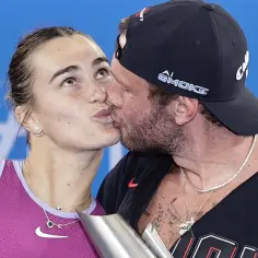 Aryna Sabalenka całuje swojego partnera po zwycięstwie.