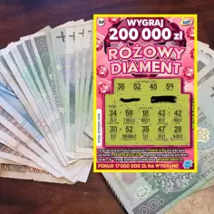Zdrapka "Różowy Diament" z wygraną 200 000 zł na tle polskich banknotów.