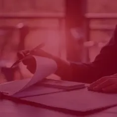 Dwie osoby przy stole, jedna przegląda dokumenty. Czy to lobbysta kto to?