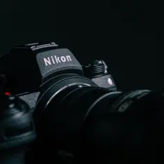 Ciemny aparat Nikon z obiektywem. Chcesz wiedzieć, jak sprawdzić przebieg aparatu Nikon?