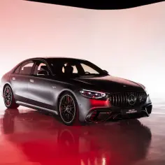 Elegancki, ciemny Mercedes S63 E Performance lśni w czerwonym świetle, gotowy na podbój dróg.