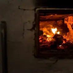 Płonące drewno w palenisku pieca.