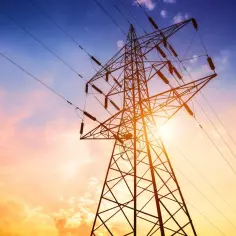 Słupy energetyczne na tle zachodzącego słońca. Zastanawiasz się, ile można dostać odszkodowania za słupy energetyczne?