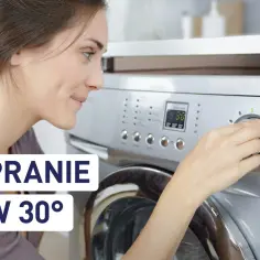 Kobieta ustawia pralkę na 30 stopni, zastanawiając się, czy pranie w 30 stopniach faktycznie zabija bakterie i roztocza.