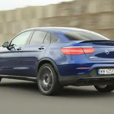 Niebieski Mercedes-Benz GLC 43 AMG coupe pędzi autostradą, zostawiając za sobą rozmyte tło.