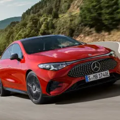 Nowy Mercedes CLA w jaskrawym kolorze pędzi po krętej drodze wśród zielonych wzgórz.